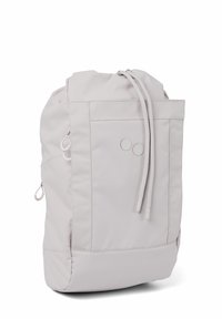 Hellgrauer Rucksack aus weichem Stoff. Verfügt über einen oberen Zugverschluss, seitliche Reißverschlusstaschen und zwei runde Akzentdetails auf der Vorderseite.