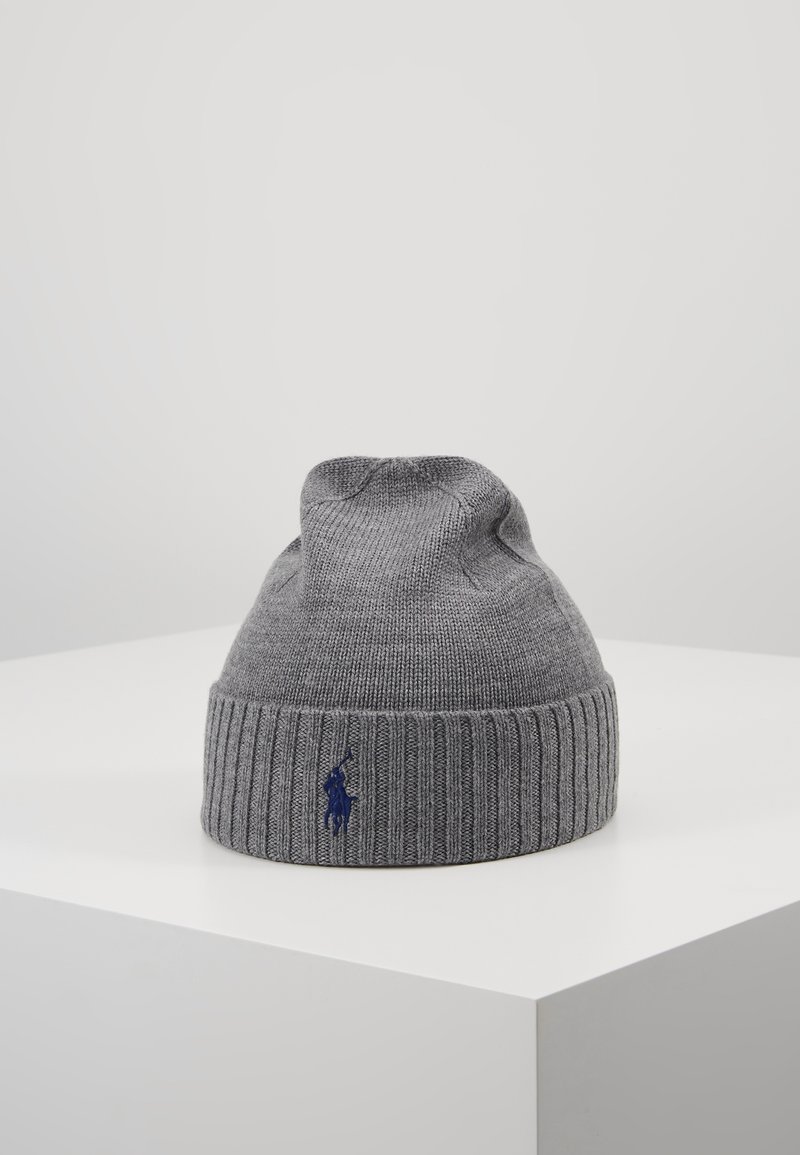 Bonnet en maille gris avec un revers côtelé plié comportant un petit logo de cheval brodé bleu foncé, présenté sur une surface blanche.