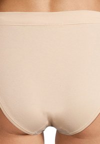 Mutandine in cotone beige con una texture liscia, dotate di una morbida cintura elastica e fianchi senza cuciture per una vestibilità confortevole.