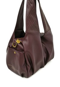 Borsa a mano in pelle color bordeaux con finitura testurizzata, manici accentuati, design con borchie sulla parte superiore e chiusura con zip con ferrature in oro.