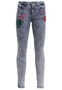 Wypłowiałe niebieskie dżinsowe rurki z kolorowymi haftowanymi kwiatami na górnej części uda, w klasycznym pięciokomorowym fasonie i zapięciem na guzik.
