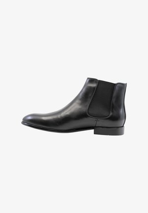 Zwarte leren Chelsea-boot met elastische zijkanten, ronde neus en een lage blokhak. Gladde textuur en gepolijste afwerking.