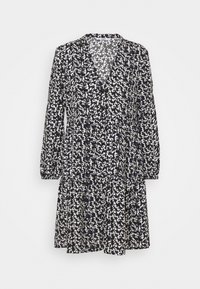 Svart och vit mönstrad klänning med långa ärmar, V-ringning och volangkjol; tyget verkar lätt med en blommönstring.