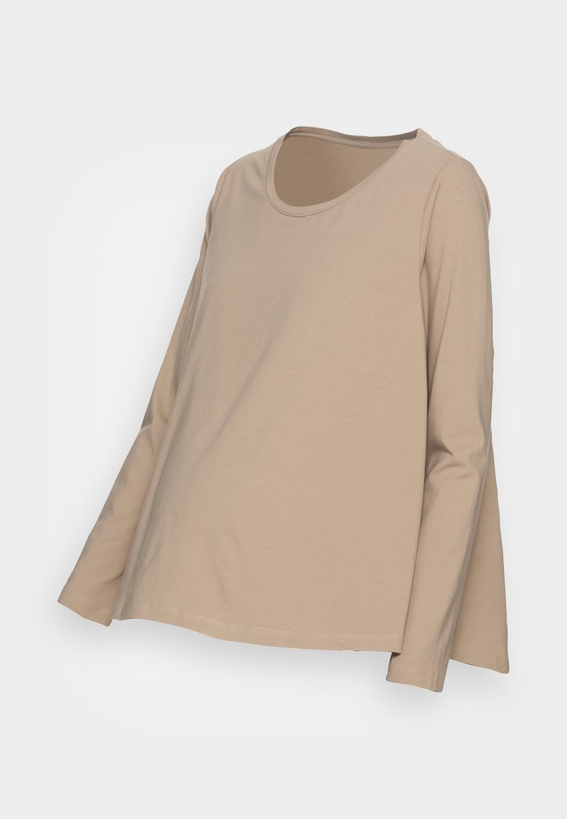 Haut beige à manches longues en tissu doux, avec un col rond et une coupe ample légèrement évasée au niveau de l'ourlet. Design sans coutures, sans matériel visible.