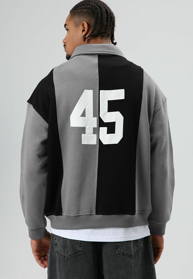 Grijs en zwart sweatshirts met kleurvlakken en een hoge kraag, met het nummer 45 in het wit op de achterkant. Zachte stof en een ontspannen pasvorm.