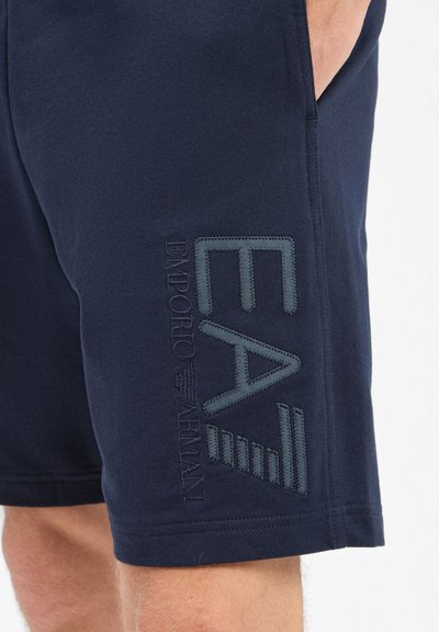 Shorts en coton bleu marine avec logo "EA" brodé et texte dans une teinte contrastante. Coupe régulière avec poches latérales et bords ourlés.