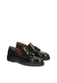 Mustad nahast loafers, millel on ripsmed, sile tekstuur, ümar nina ja madal, paks kant stabiilsuse tagamiseks.
