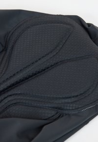 Nahaufnahme von schwarzen, gepolsterten Radsport-Shorts mit strukturiertem Muster, konturierten Nähten und gepolsterten Bereichen für Komfort.