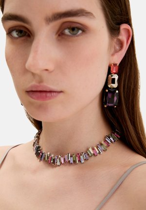 Kleurrijke ketting met rechthoekige metalen schakels in roze, paars en groen, gecombineerd met geometrische oorbellen in bijpassende tinten.