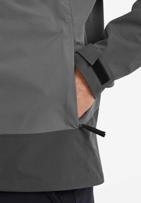 Gray waterproof jacket featuring a smooth texture, zippered side pocket, and adjustable velcro cuff, with a contrasting bottom hem.