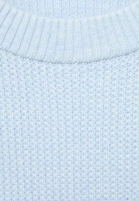 Svetlo modra pletena tkanina s rebrasto teksturo, ki ima okroglo ovratnik in vidne vodoravne ter navpične vzorce preje.