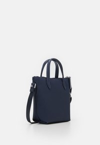 Borsa a mano blu navy con due manici superiori, una tracolla removibile, forma rettangolare elegante e una superficie testurizzata. Dettagli hardware in argento.