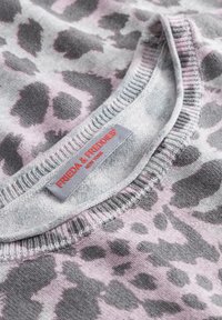 Grijze trui met roze luipaardvlekken. Geribbelde halslijn, textiel stof en een label met "Frieda & Freddies, New York."