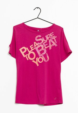 Camiseta de manga corta color rosa brillante en percha negra con texto en melocotón y rosa claro que dice "Un placer ganarte", en diagonal en la parte delantera.