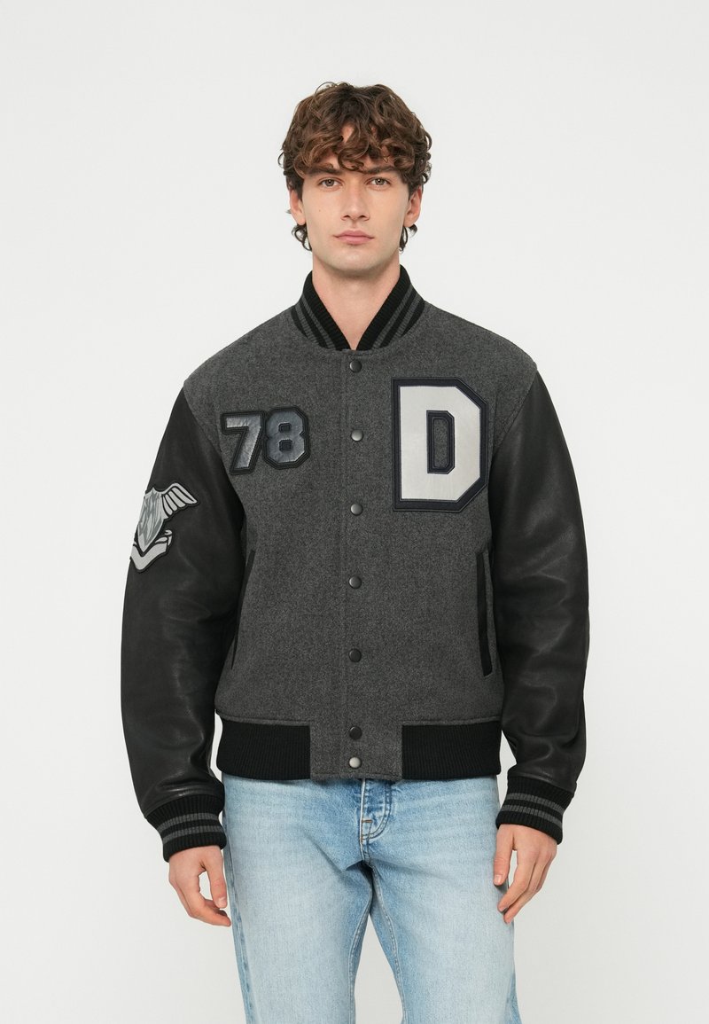 Šedá univerzitn�á bunda z vlnenej zmesi s čiernymi koženými rukávmi, rebrovaným golierom a elastickými manžetami. Na hrudi má nášivky "78" a "D".