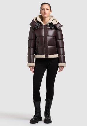 Mørkebrun pufferjakke med fleece-lineret hætte, sorte detaljer og shearlingmanchetter. Designet har en cropped pasform og en boxy form.