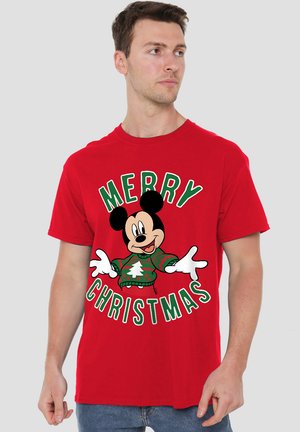 Rotes Baumwoll-T-Shirt mit einem zentralen Grafik eines Cartoon-Charakters, umgeben von dem Text "FROHE WEIHNACHTEN" in Grün und Weiß.