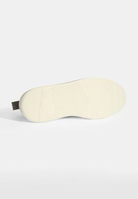 Shoe sole with textured pattern, featuring a white rubber material and a dark textile strip at the heel for grip and comfort.