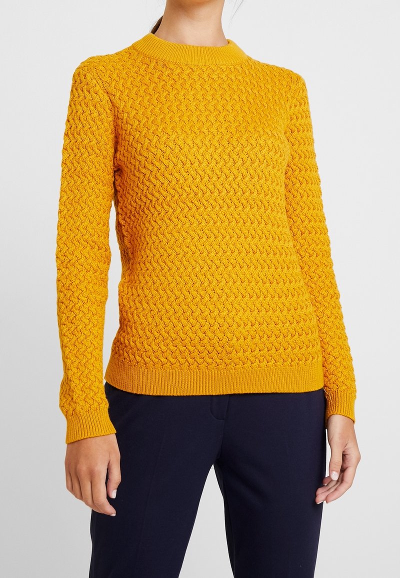 Pletený svetr v jasně žluté barvě, s texturovaným vzorem a kulatým výstřihem. Hladké manžety a lem, s přiléhavou siluetou pro pohodlné nošení.