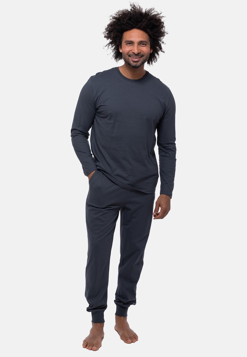 Set da loungewear in cotone grigio scuro composto da una maglia a maniche lunghe con scollatura a girocollo e pantaloni affusolati coordinati con polsini elasticizzati e tasche.