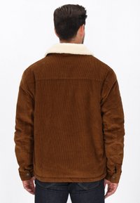Braune Cordjacke mit weißen Kunstpelzkragen und Knopfmanschetten, mit strukturiertem Finish und geradem Saum.