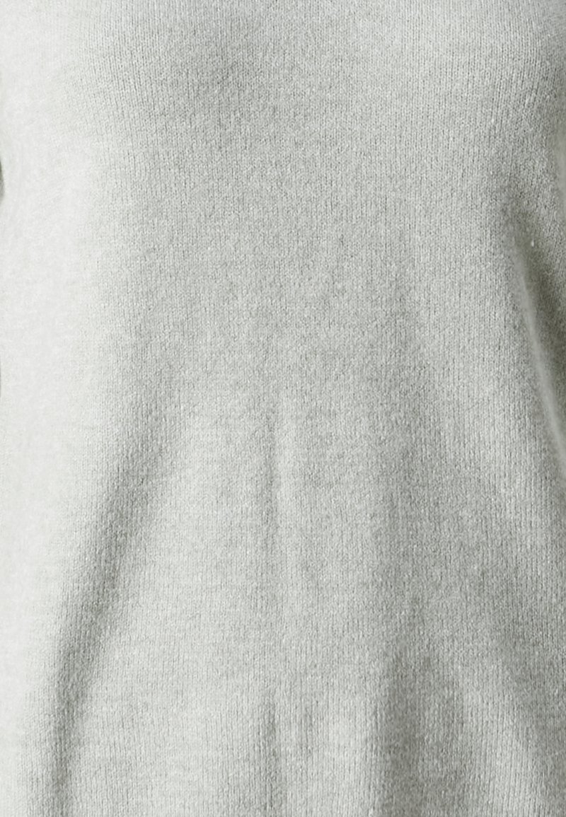 Pull en maille tricotée douce de couleur gris clair, à la texture lisse et au design simple et dépouillé, offrant une coupe décontractée.