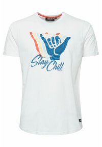 Camiseta de algodón blanca con un diseño gráfico que incluye el texto "Stay Chill" y coloridas ilustraciones de manos estilizadas en azul, rojo y amarillo.