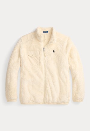 Cream-colored fleece jacket with zip front, high collar, side pockets, and a small logo on the chest. Soft, textured fabric.
