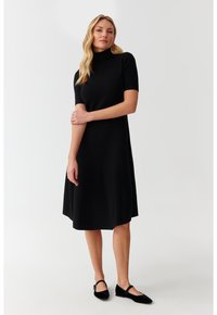 Mustmustelg dress, mille pikkus ulatub põlvini, faux-korki ja lühikeste varrukatega. Valmistatud pehmest kangast, omab lihtsat ja lõdvestunud siluetti.