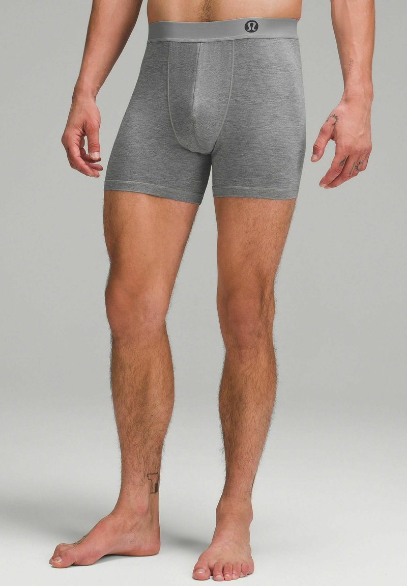 Graue Baumwoll-Boxershorts mit enganliegendem Design, elastischem Bund und glatter Textur. Verfügt über einen zentralen Pouch und ein kontrastierendes Logo am Bund.