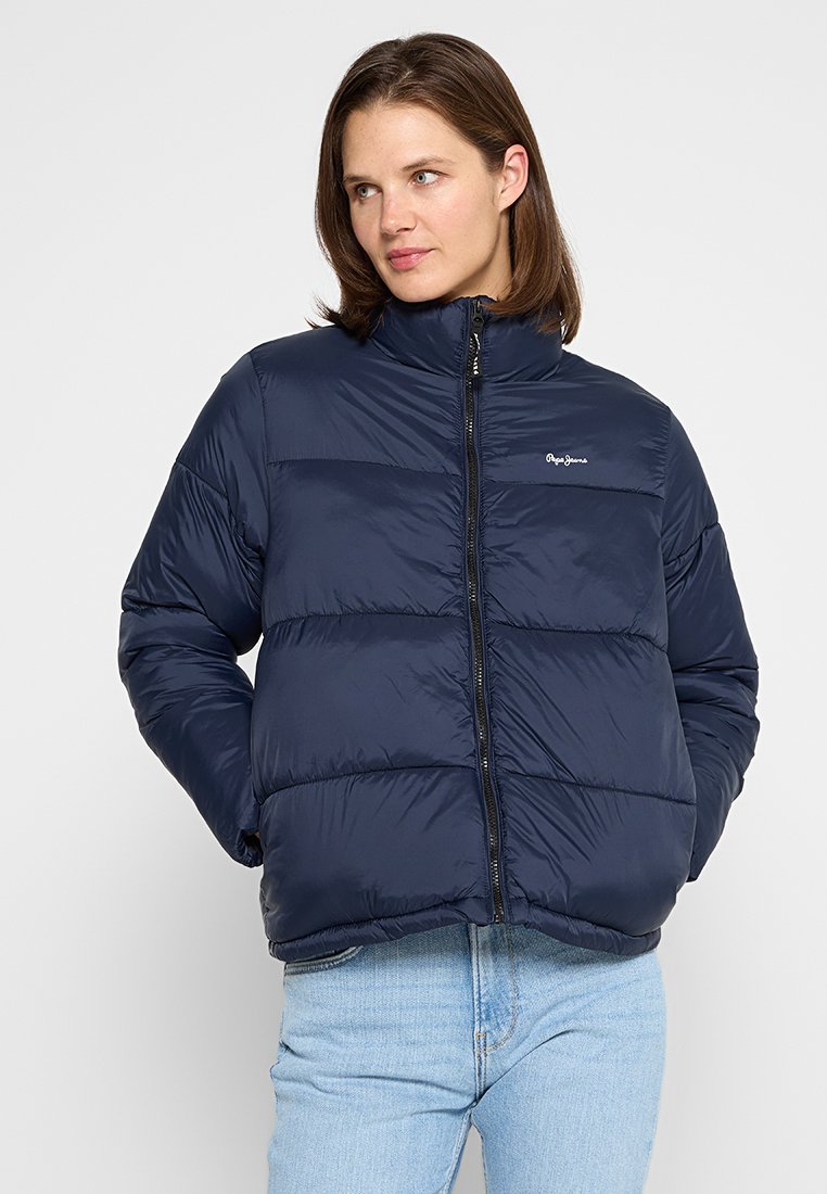 Chaqueta de plumas azul marino con cuello alto, cierre de cremallera en la parte delantera y costuras horizontales. Fabricada con material brillante y ligero. Presenta un logotipo en el pecho.