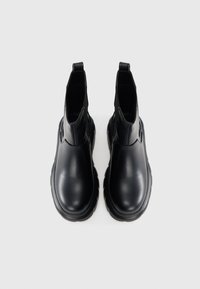 Melni potītes zābaki no spīdīgas ādas, ar apaļu purngalu un elastīgām sānu paneļiem. Bieza gumijas sole ar teksturētu zīmējumu.