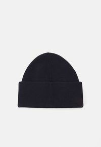 Beanie lavorata a maglia di colore navy con risvolto. Presenta una superficie liscia e una parte superiore arrotondata. Design semplice e minimalista senza ulteriori decorazioni.