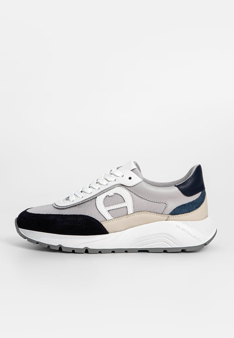 Sneaker aus einer Mischung von grauen, marineblauen und beige Materialien. Verfügt über ein Obermaterial aus Mesh, Wildlederakzente, weiße Schnürsenkel und eine dicke weiße Sohle.