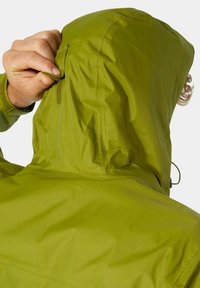 Zielona wodoodporna kurtka z kapturem, z regulacją na sznurki i teksturowanym materiałem. Z tyłu widoczny jest gładki, uszczelniony szew.