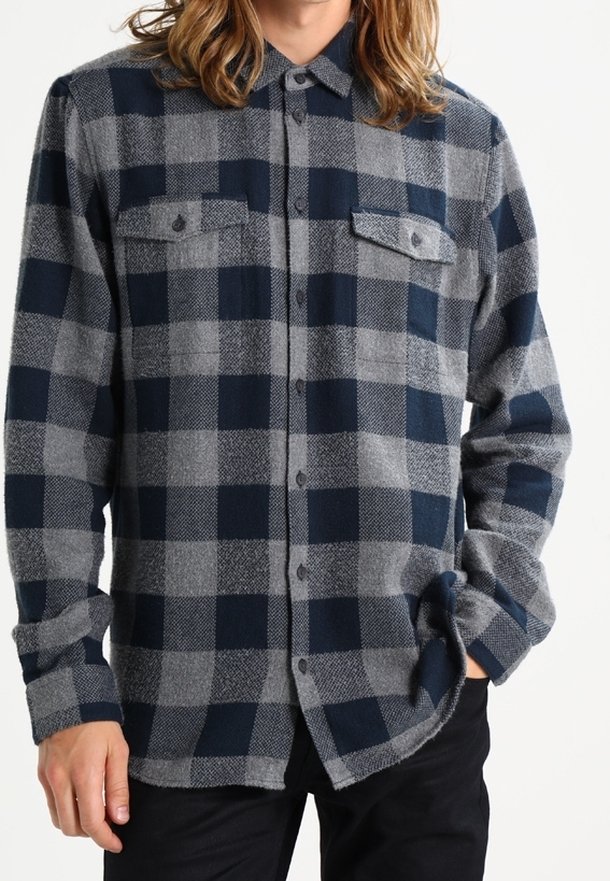 Marineblauwe en grijze geruite flanellen shirt met knoopsluiting, twee borstzakken en lange mouwen. Zachte textuur met een relaxed fit.