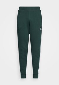 Tmavě zelené zúžené tepláky s elastickým pasem, manžetami u kotníků, bočními kapsami, bílými bočními pruhy a malým logem Adidas na levém stehně.