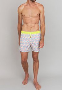 Shorts de bain avec un motif géométrique multicolore, une taille élastique jaune fluo et un cordon de serrage. Fabriqués en tissu léger.