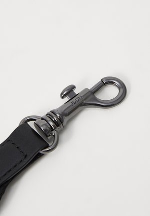 Czarny pasek ze skóry połączony z metalowym obrotowym karabińczykiem w kolorze gunmetal, na którym wygrawerowano napis "JOOP.".