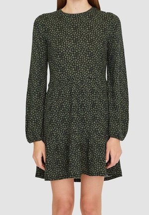 Robe à manches longues, vert foncé, avec un petit imprimé floral blanc, taille cintrée et jupe légèrement évasée se terminant au-dessus des genoux.