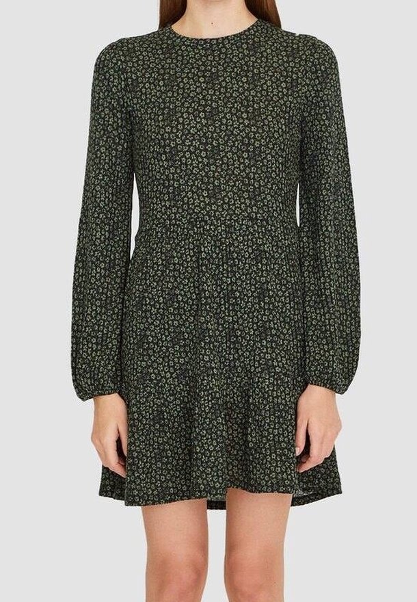 Robe à manches longues, vert foncé, avec un petit imprimé floral blanc, taille cintrée et jupe légèrement évasée se terminant au-dessus des genoux.