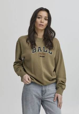 Olive green sweatshirt with "BALL" graphic in black and cream, crew neckline, dropped shoulders, and ribbed cuffs, paired with light gray jeans.
