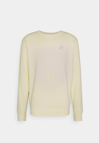Sudadera de algodón amarilla con mangas largas, cuello redondo y pequeño logo de Nike en púrpura en el lado izquierdo del pecho. Textura suave y corte holgado.