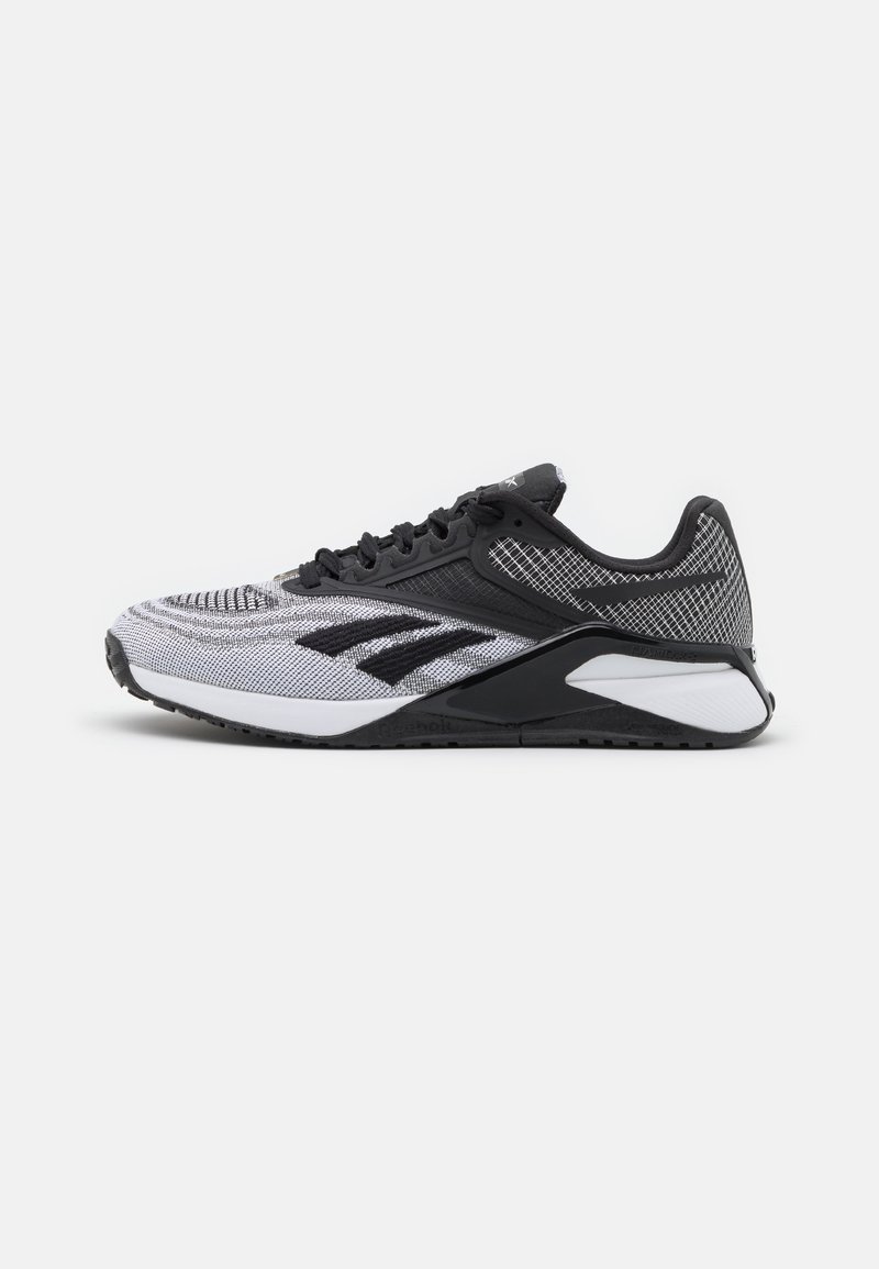Svart och vit atletisk sko med en texturerad mesh-övre, framträdande logotypaccenter och en dämpad sula med en distinkt form.