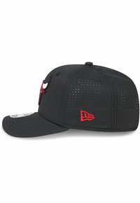 Gorra negra ajustada con un diseño perforado, que presenta un logotipo de toro rojo bordado y costuras rojas en contraste en el lado.