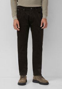 Brown corduroy pants with a straight fit, featuring front pockets, a belt loop, and worn with beige suede boots.