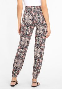 Musterhosen mit einem mehrfarbigen Blumen- und geometrischen Design, elastischem Bund und gerafften Bündchen an den Knöcheln.