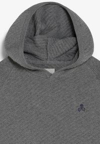 Hoodie en maille grise avec un motif côtelé diagonal et un petit logo sombre de tête de mort et tibias croisés sur la poitrine.