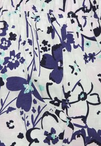 Floral fabric featuring purple, black, and mint green flowers on a light background. Soft, textured material with gathered elastic waistband detail.