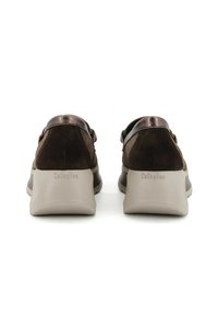 Scarpe in suede marrone con un accento metallico sul tallone, una suola beige imbottita e un logo posteriore che recita "Callaghan."